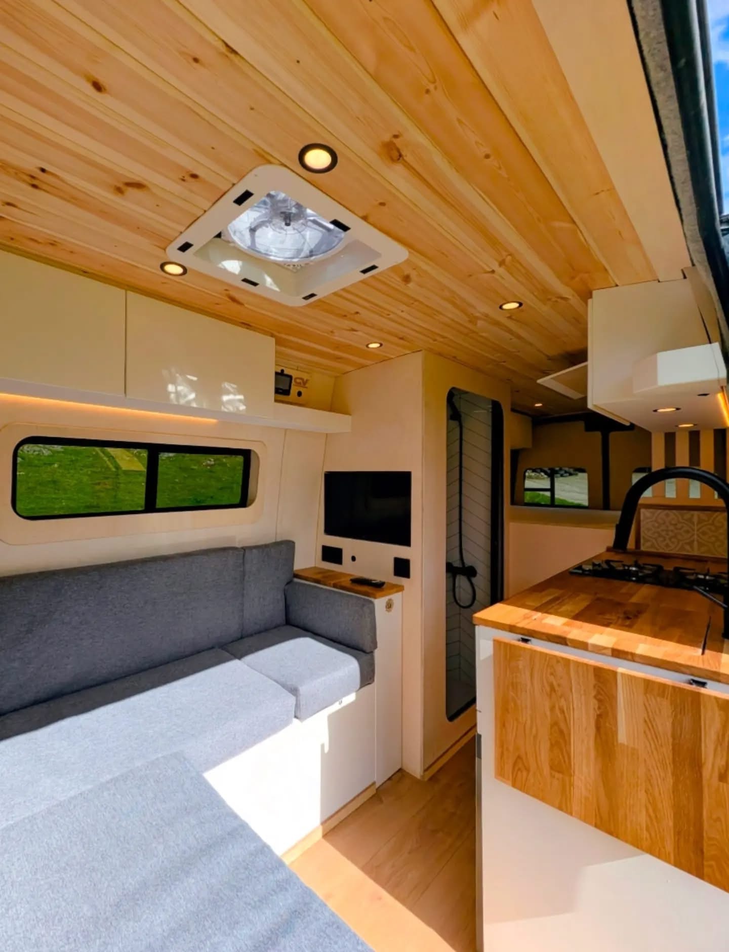L-shaped lounge seating with fold-down table and pine ceiling